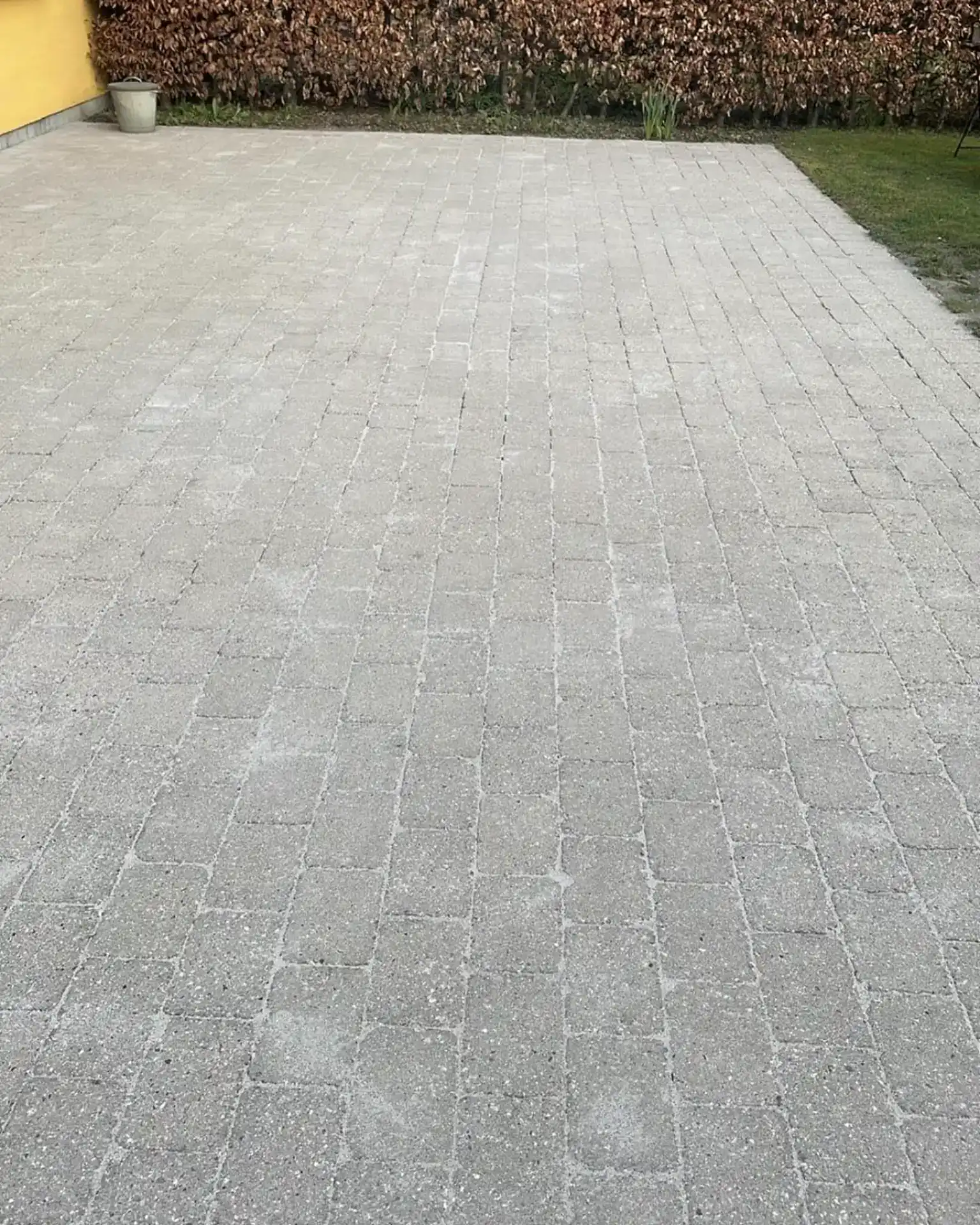 Havedækkende belægning med grå sten til terrasser og indkørsler.